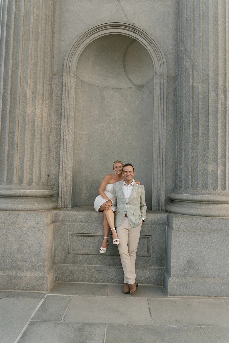 Ellie and Marcus in a stone niche between two columns
